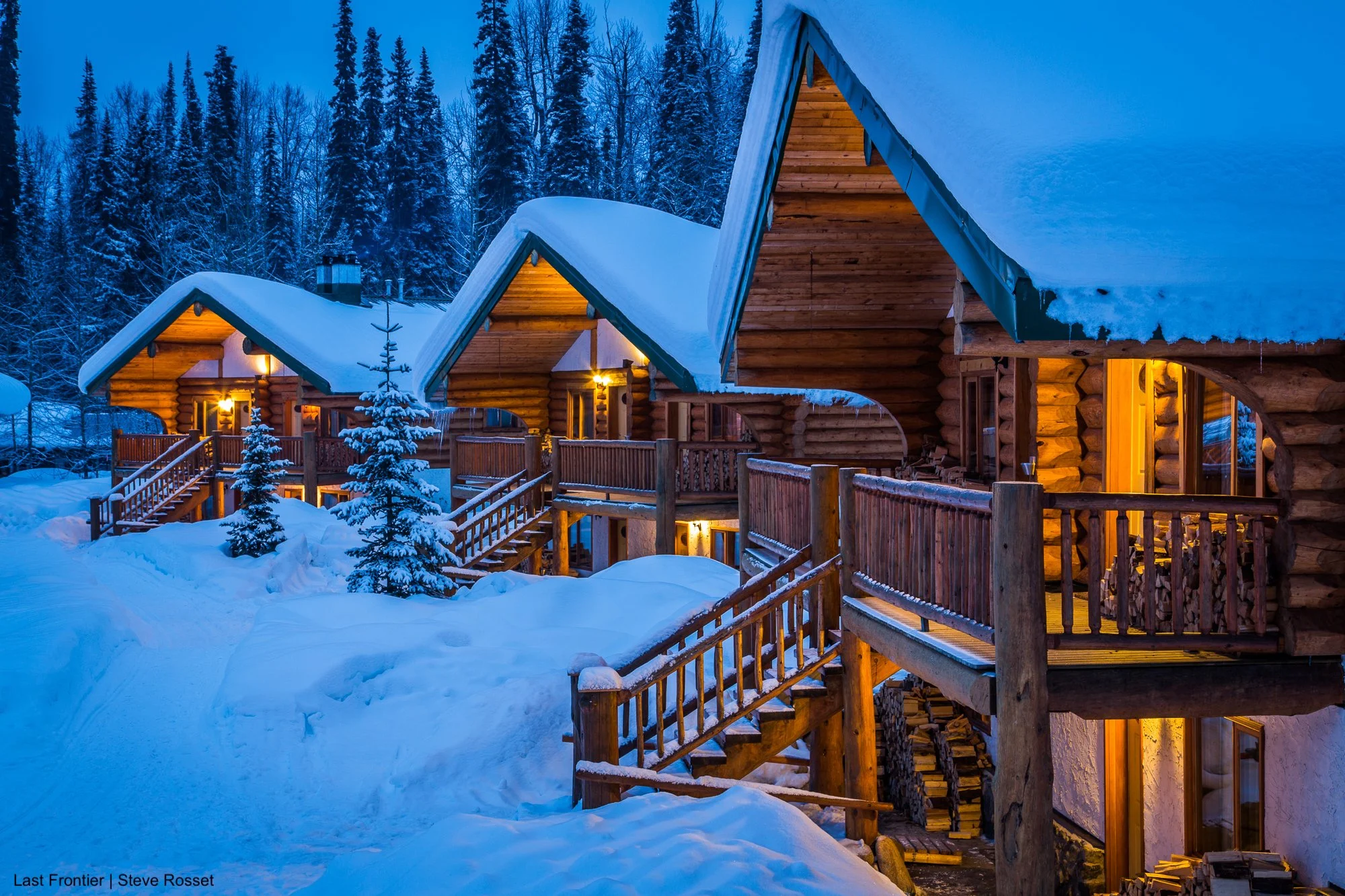Bell 2 Lodge's custom-built log chalet cabins in the evening light.