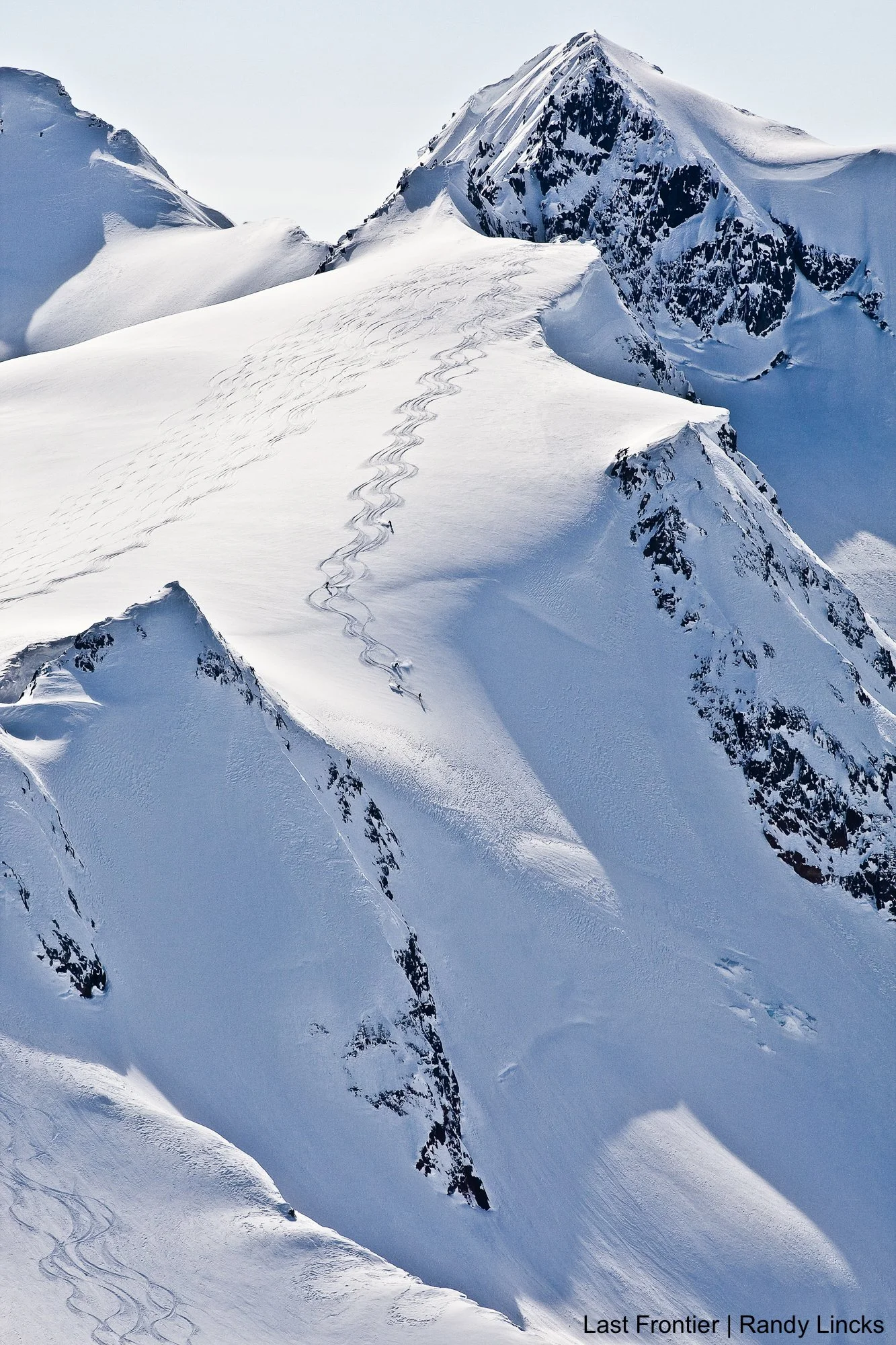 Skier descending a long alpine run in the Coast and Skeena Mountains surrounding Bell 2 Lodge.