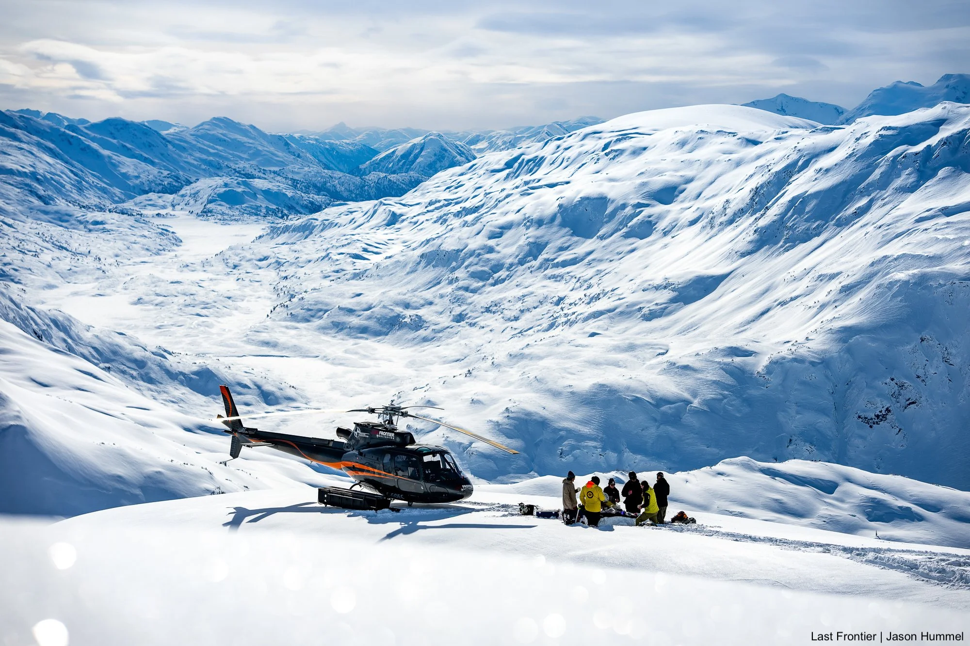 Guests enjoying a picnic beside the helicopter on a remote alpine ridge.