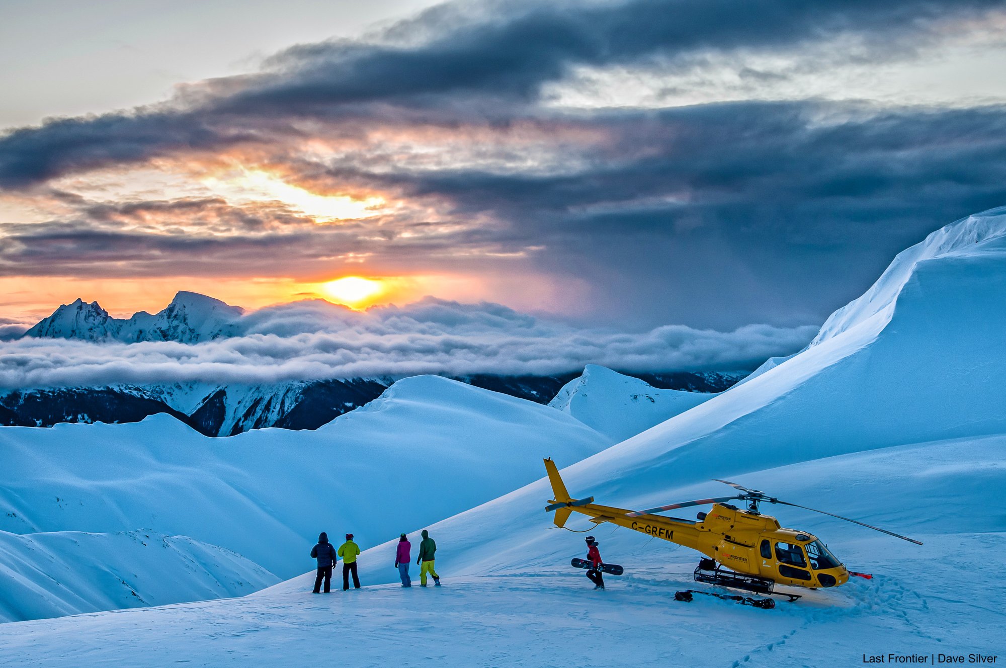 Group of heli skiers enjoy sunset views before flying back to ripley creek lodge