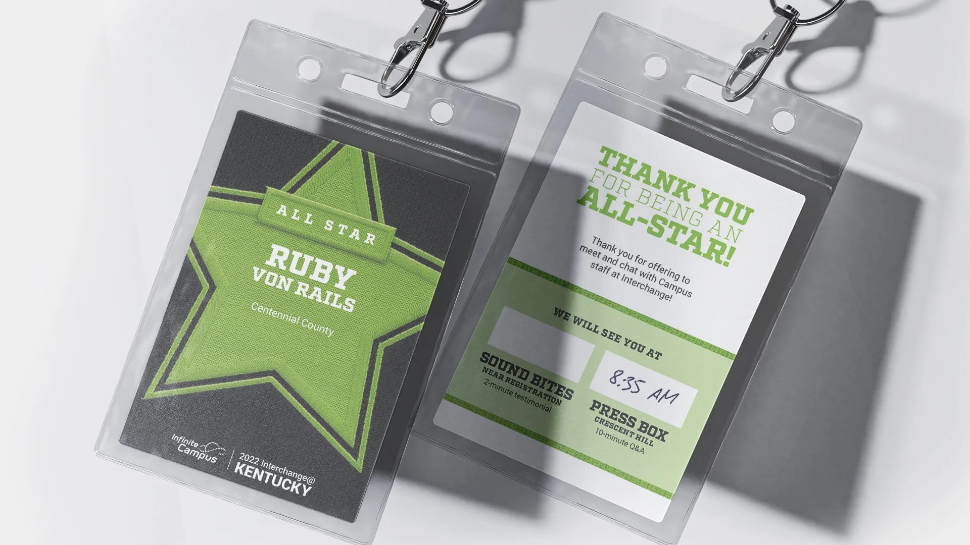 Two clear plastic badge holders, each containing a badge. The left badge features a green and black star design with text reading 'ALL STAR RUBY VON RAILS' and 'Centennial County'. The right badge contains a thank you message for being an all-star, with a schedule, name '8:55 AM', and timeline details.