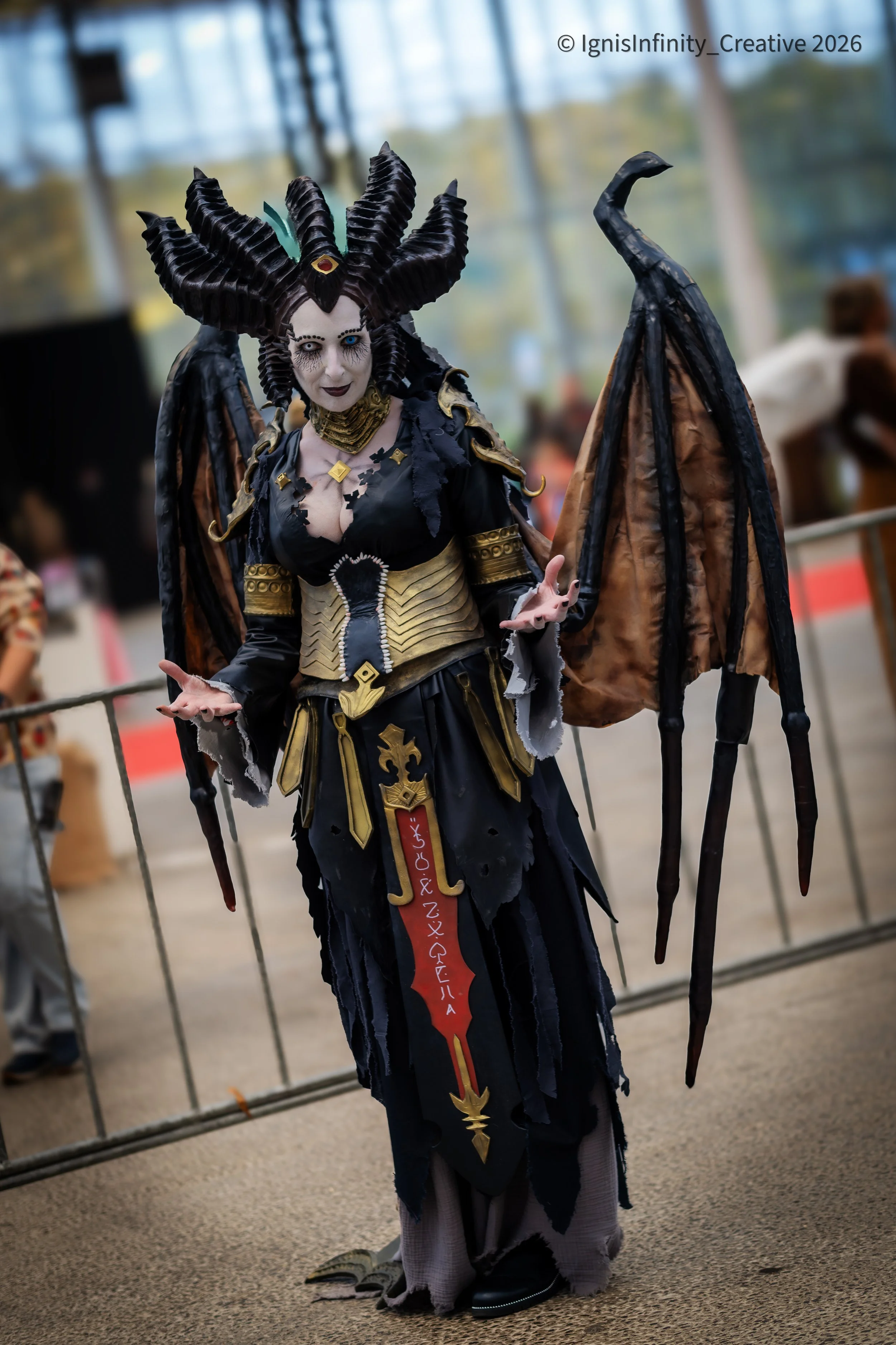 Lilith (Diablo IV) reigning supreme – horn crown, black wings, gold armor and runic blade at convention.
Photographer: IgnisInfinity Creative | Cosplayer: @chaos.creates.cosplay

