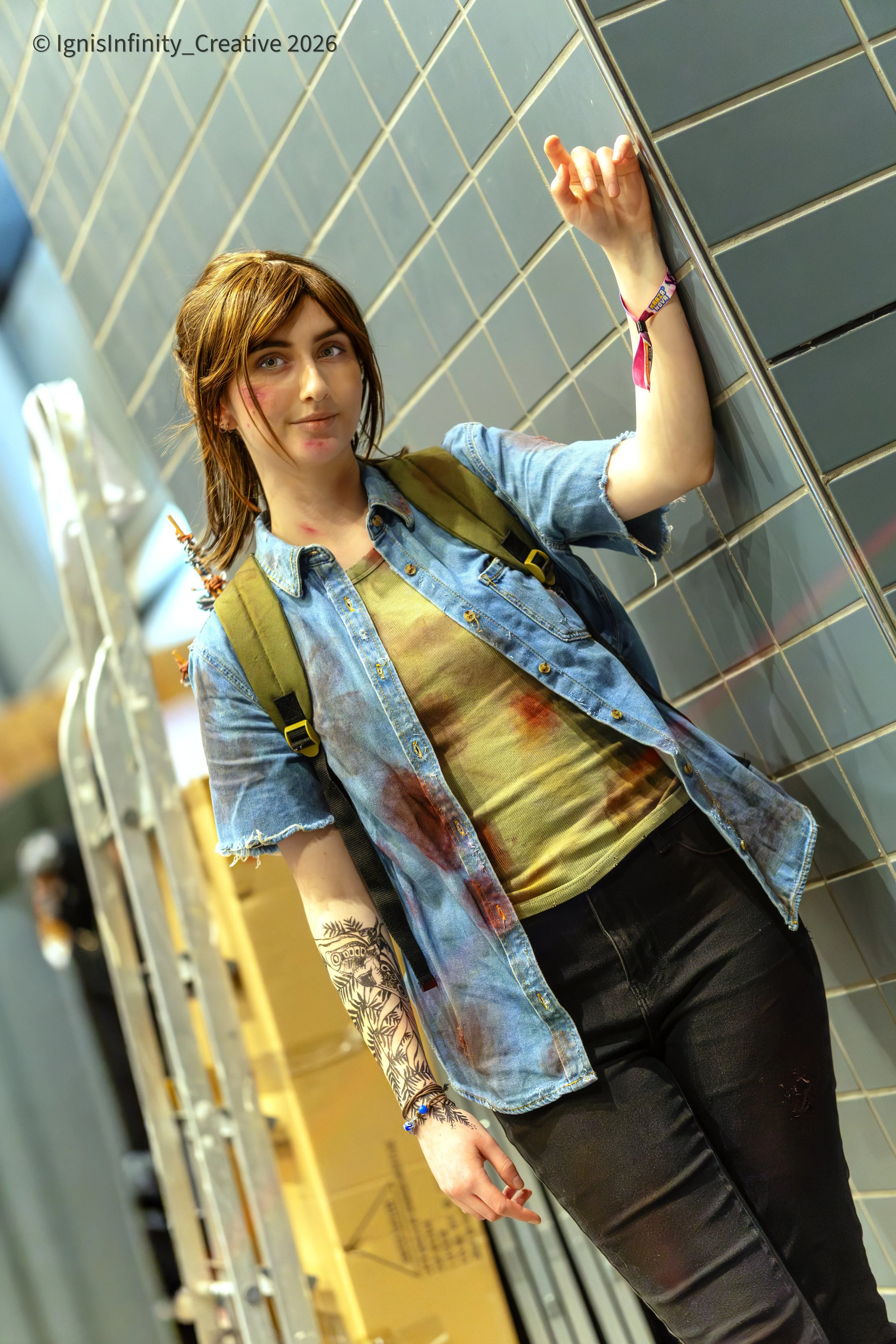 Ellie (The Last of Us) surviving another day – bloodied denim jacket, tattoo and fierce convention pose.
Photographer: IgnisInfinity Creative | Cosplayer: @hermelijn.04

