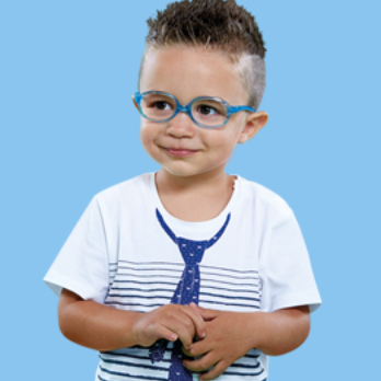 Young boy with glasses and a striped shirt with a tie, smiling against a blue background.