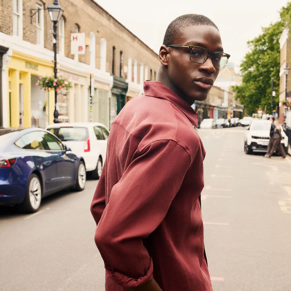 A man wearing low-bridge spectacles in the street