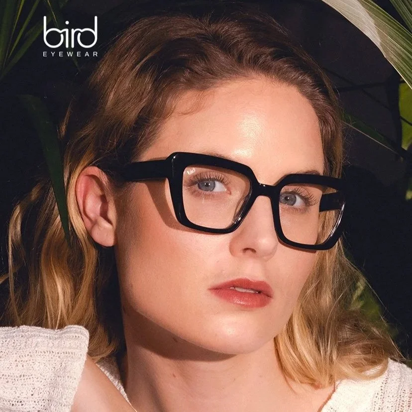 A picture of a woman with black chunky frame glasses from Bird Eyewear