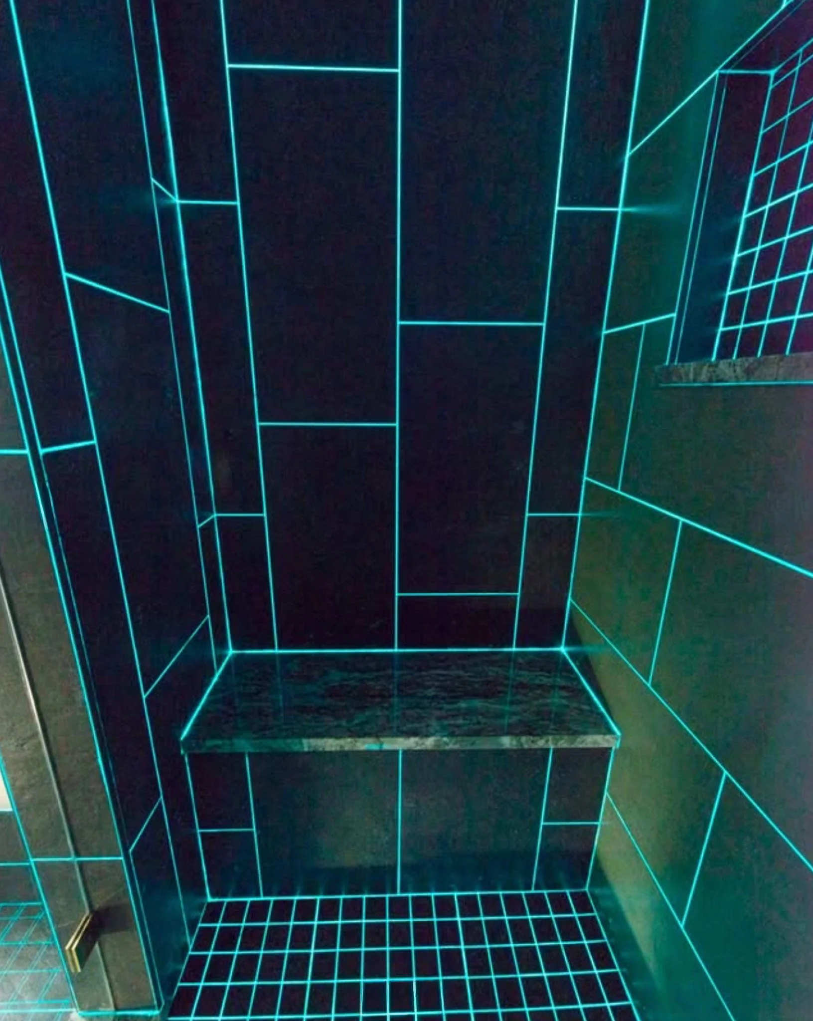 An elevator with walls and floor outlined in glowing neon blue grid lines, creating a futuristic and digital appearance, with a reflective metallic door on the left side.