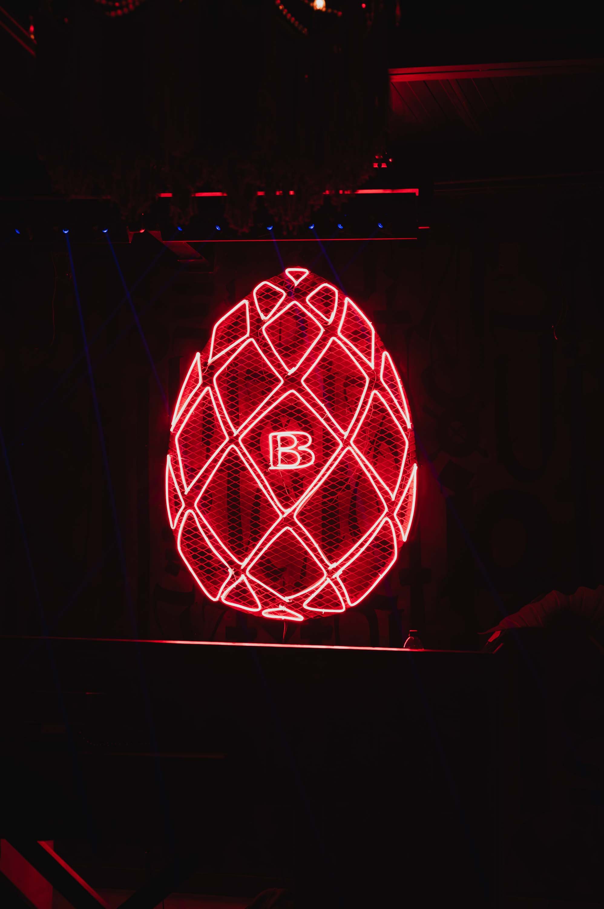 Neon red pineapple-shaped sign with a letter B in the center.