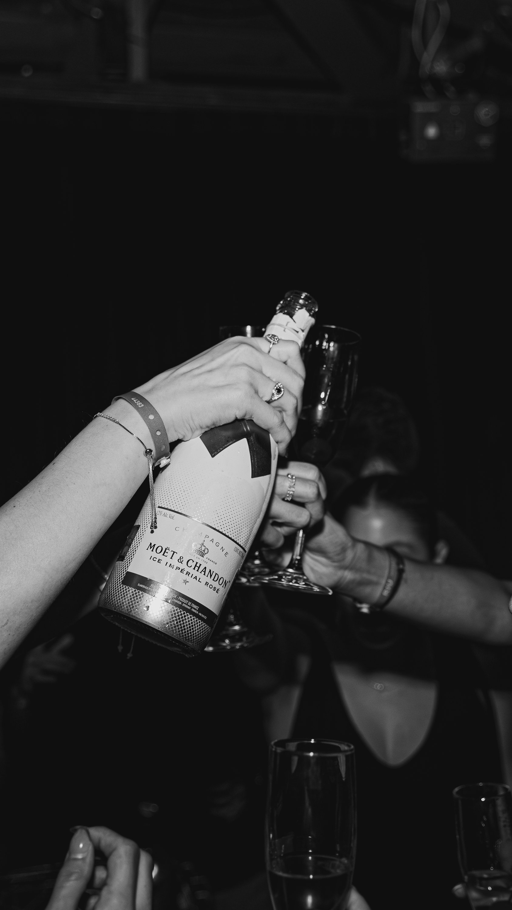 People clinking glasses and pouring champagne, celebrating at a party.