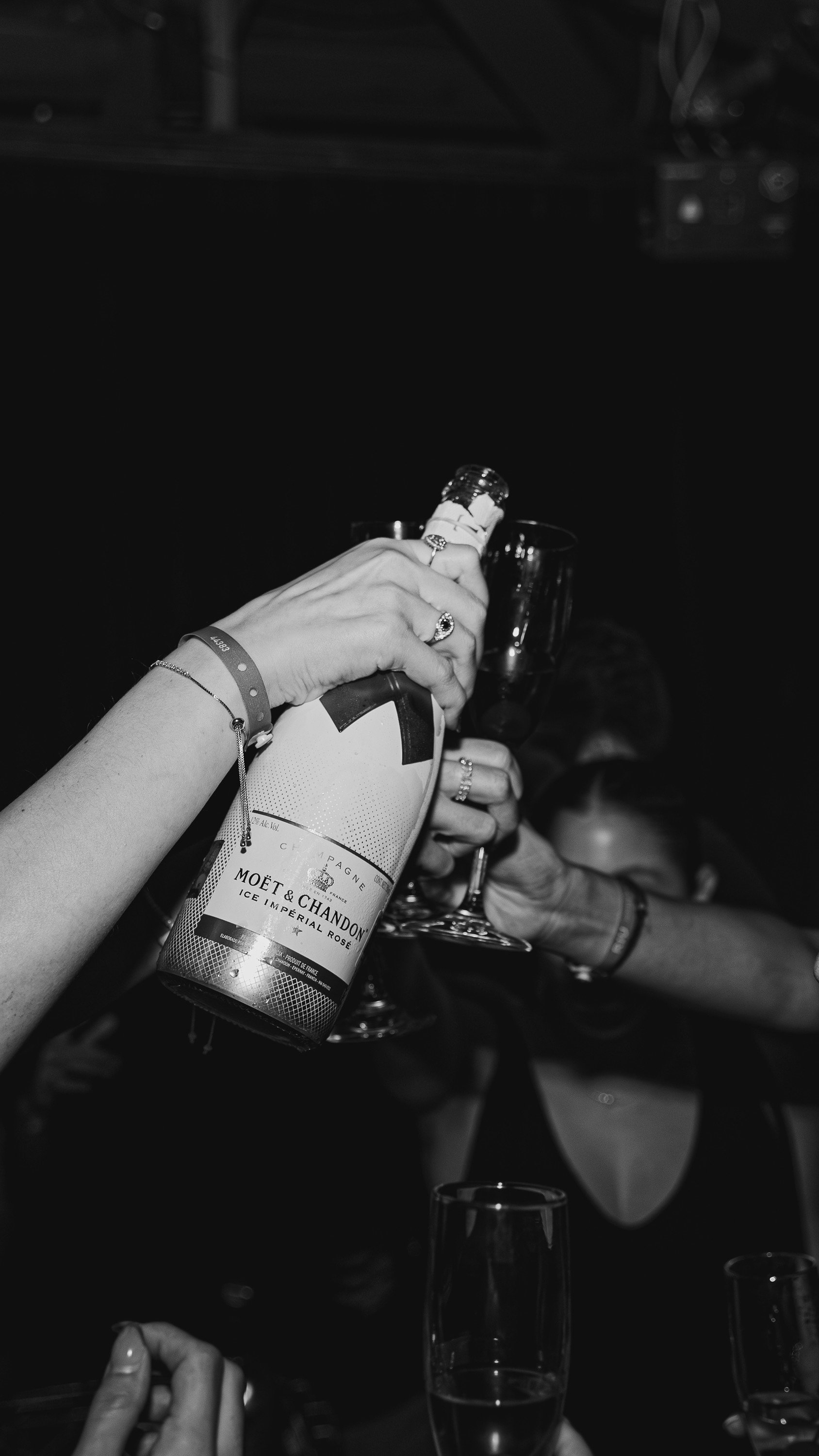People celebrating with a bottle of Moët & Chandon champagne and glasses at a party.