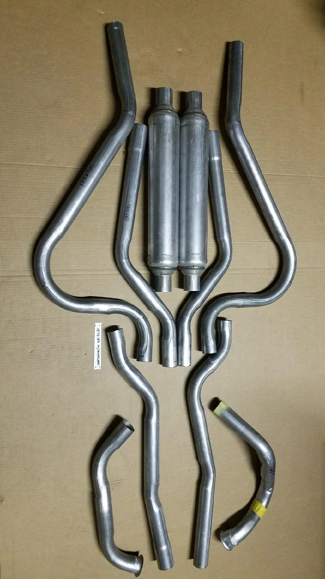 Complete 10-piece dual exhaust system for 1975-1985 Avanti II featuring 409 stainless pipes and round seamless mufflers.