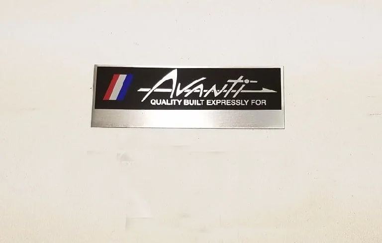 Close-up of Avanti II console dash plaque with decorative stripes and 'Quality Built Expressly For' text.