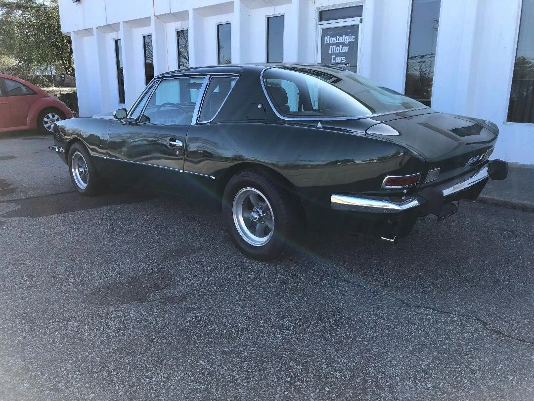 Side rear view of 1981 Avanti II in British Racing Green with high-performance stance.