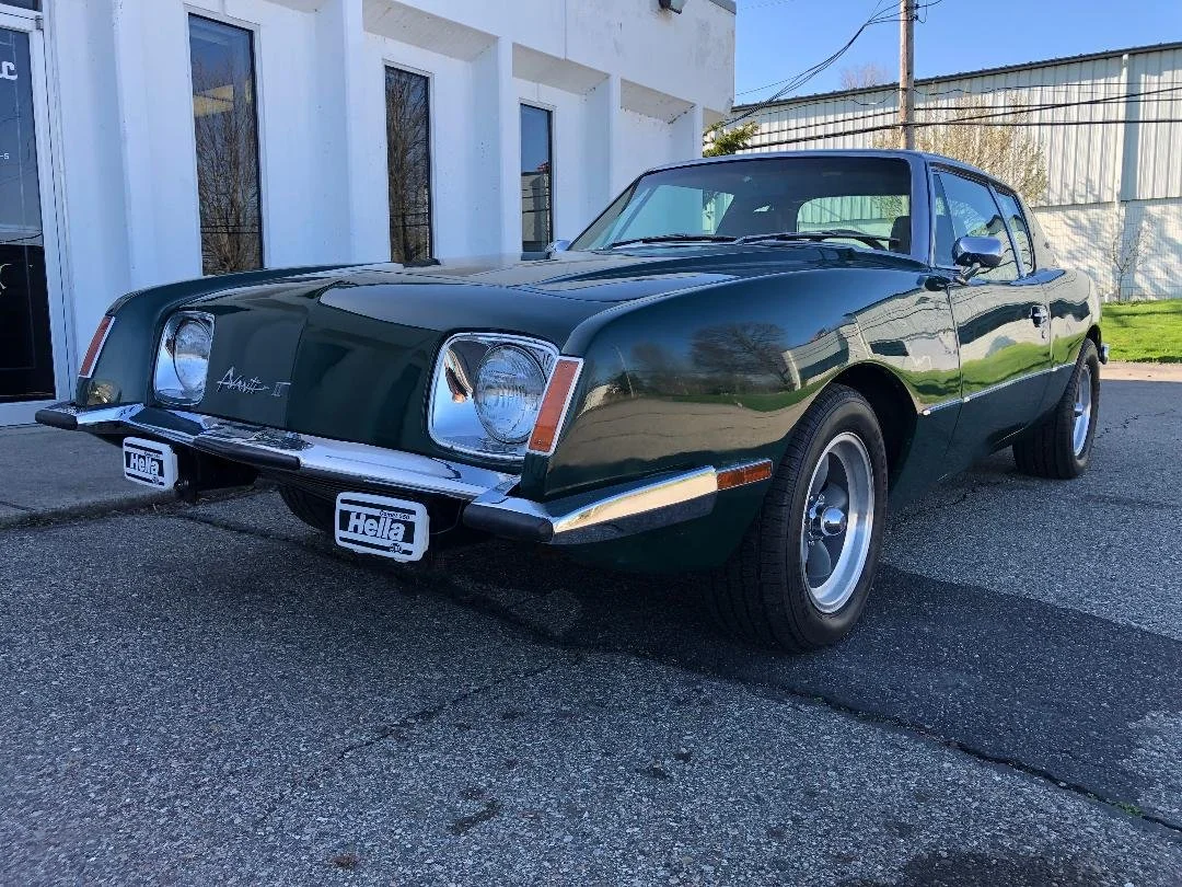 Front view of 1981 Avanti II in British Racing Green with high-performance stance.
