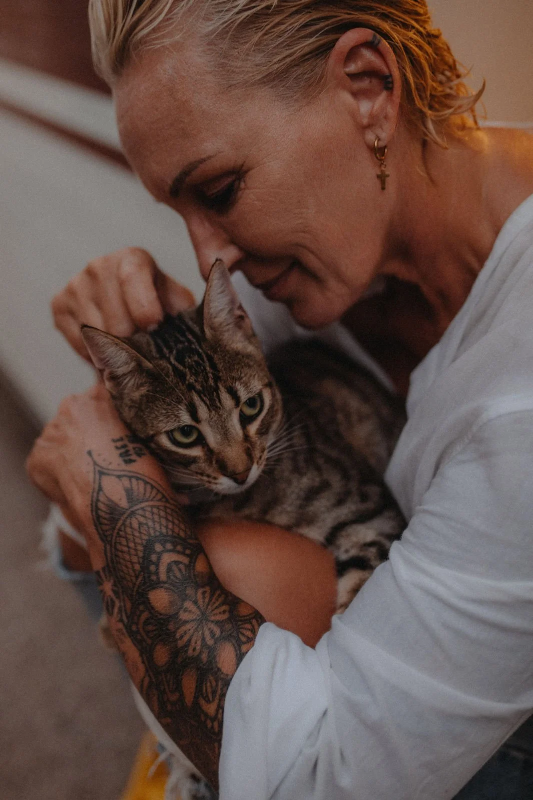 Nadine Miree hält eine Katze im Arm, sie drücken ihre Stirn zusammen und scheinen sich zu lieben.