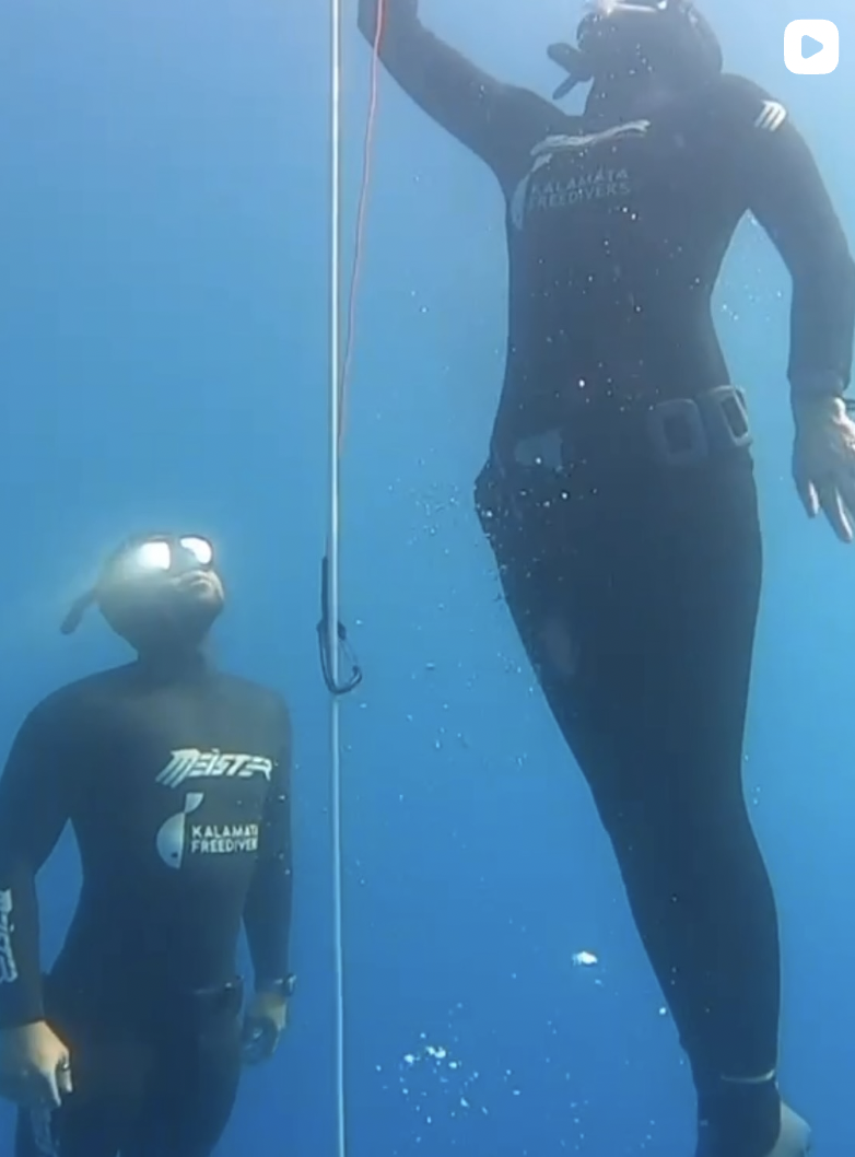 freediver underwater with safety diver