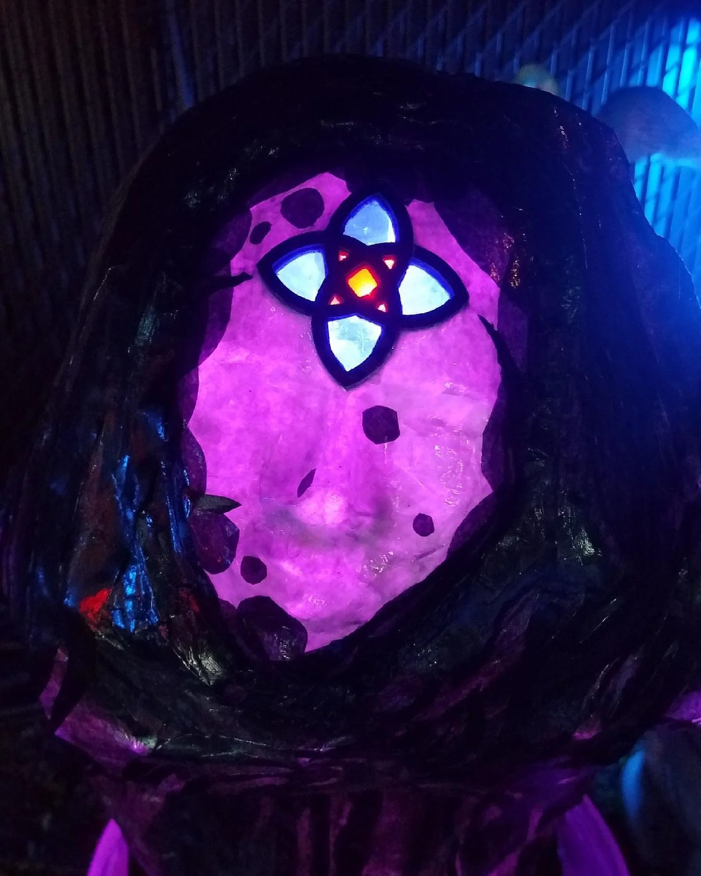 Colorful glowing lantern with a purple background, blue and red accents, and a floral design at the top.