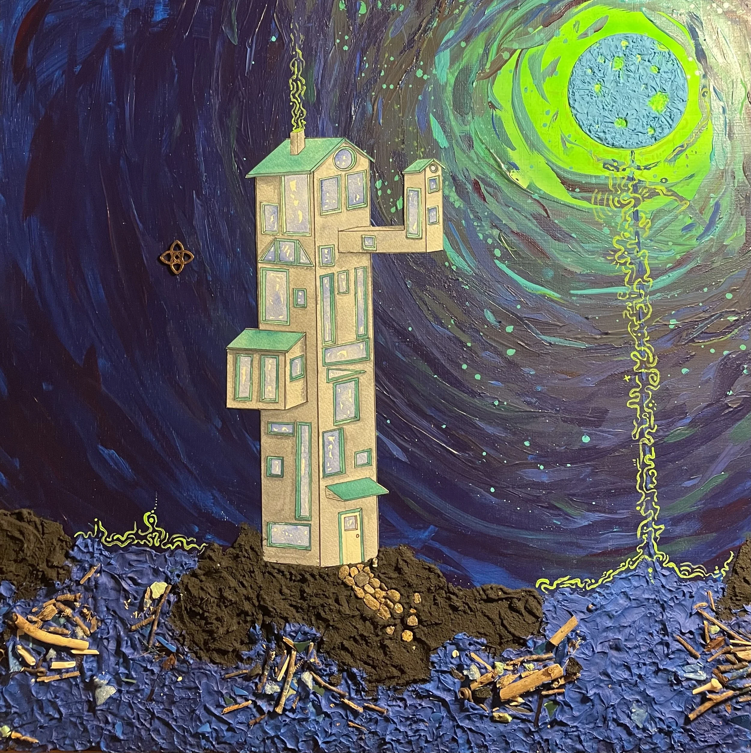 A mixed media artwork featuring a house with multiple windows and green roofs standing on uneven, textured ground made of dark textured material and blue shredded paper. In the background is a swirling night sky painted in shades of blue, purple, and
