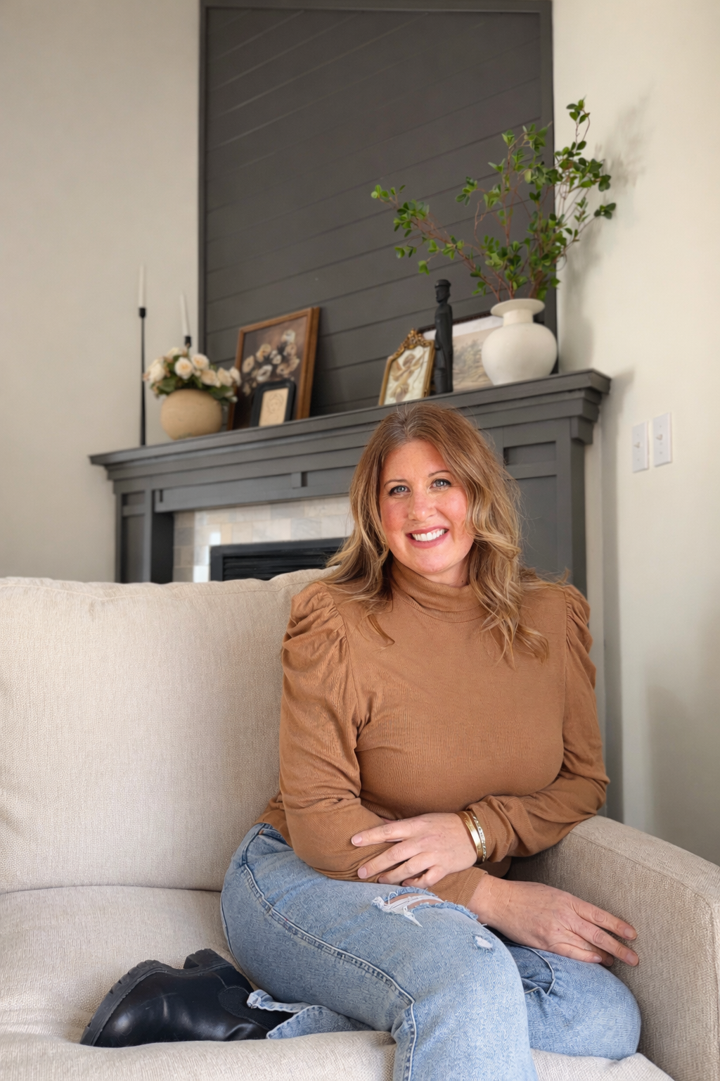 The Principal Broker of The Avenue Real Estate Group sitting in a warm, residential setting, representing personal attention and direct communication for clients.