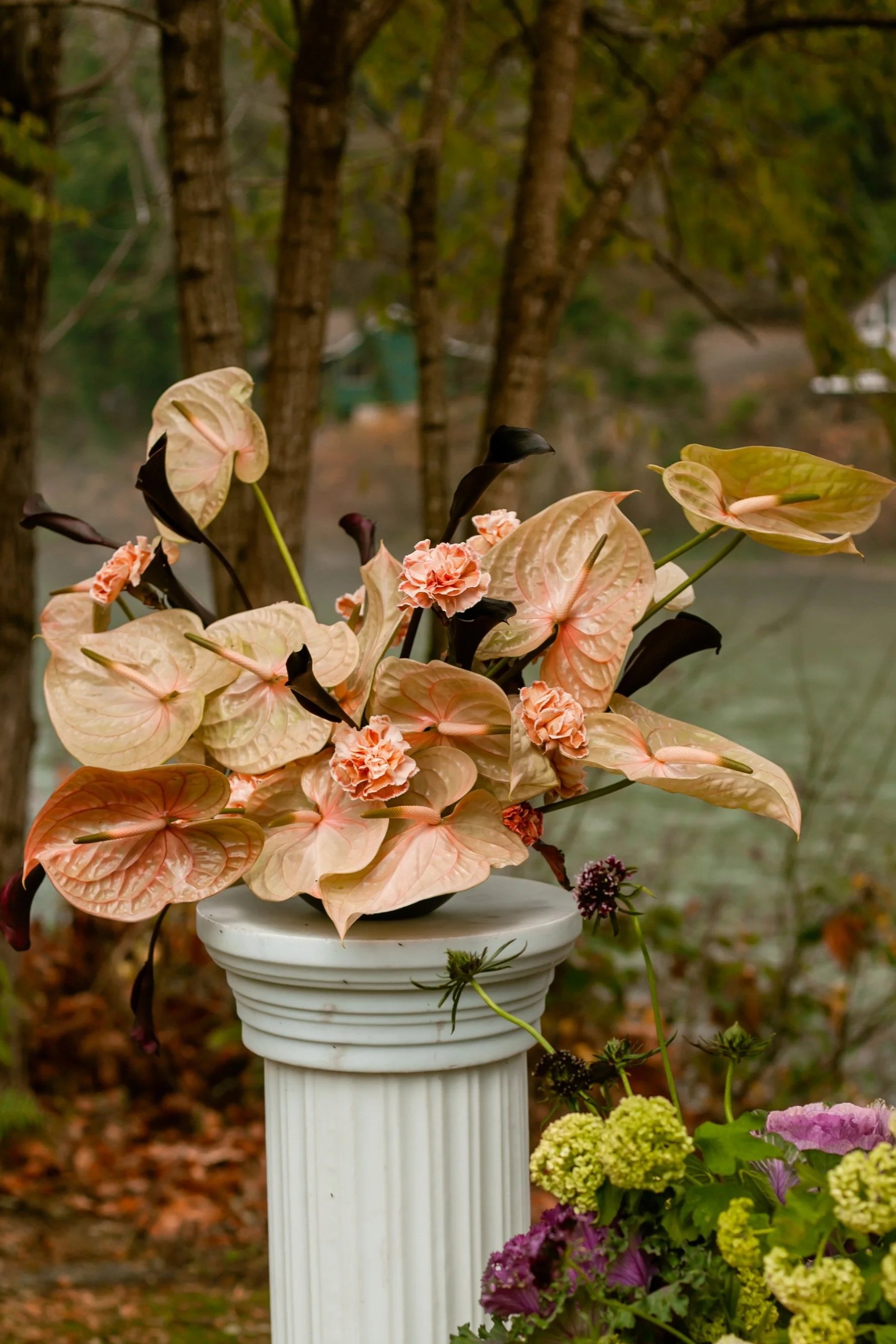 moody and editorial arrangement for a wedding ceremony with pink and black flowers