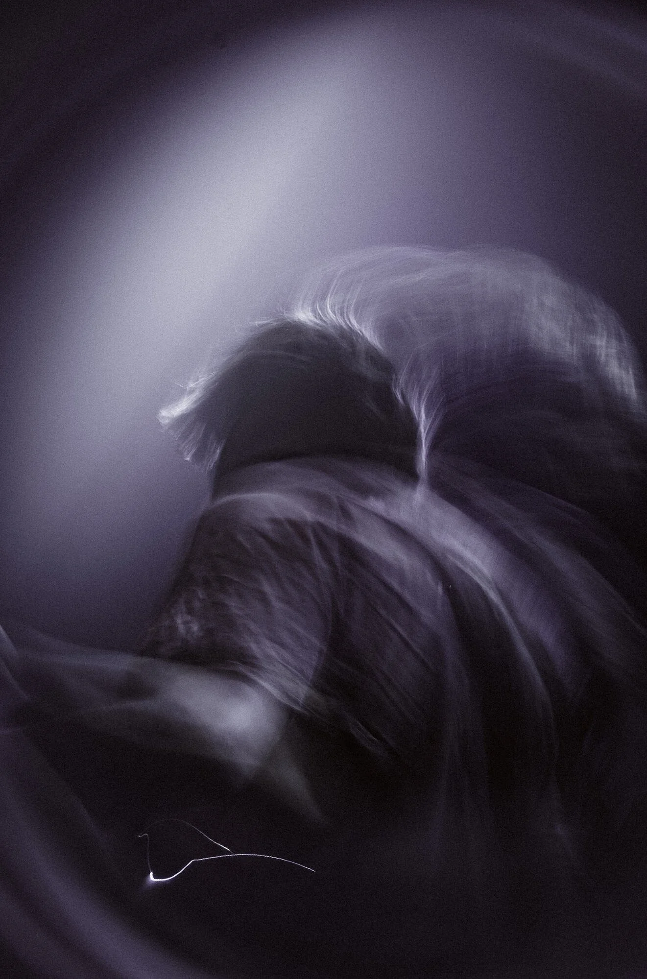 Abstract dark purple and black swirling pattern with streaks of white light.