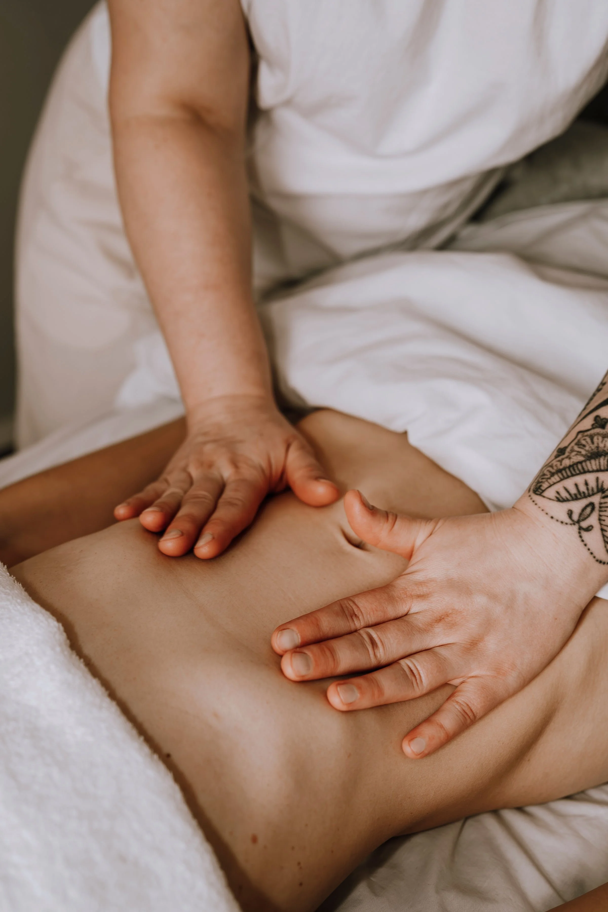 Close-up of a person receiving a massage on their abdomen.