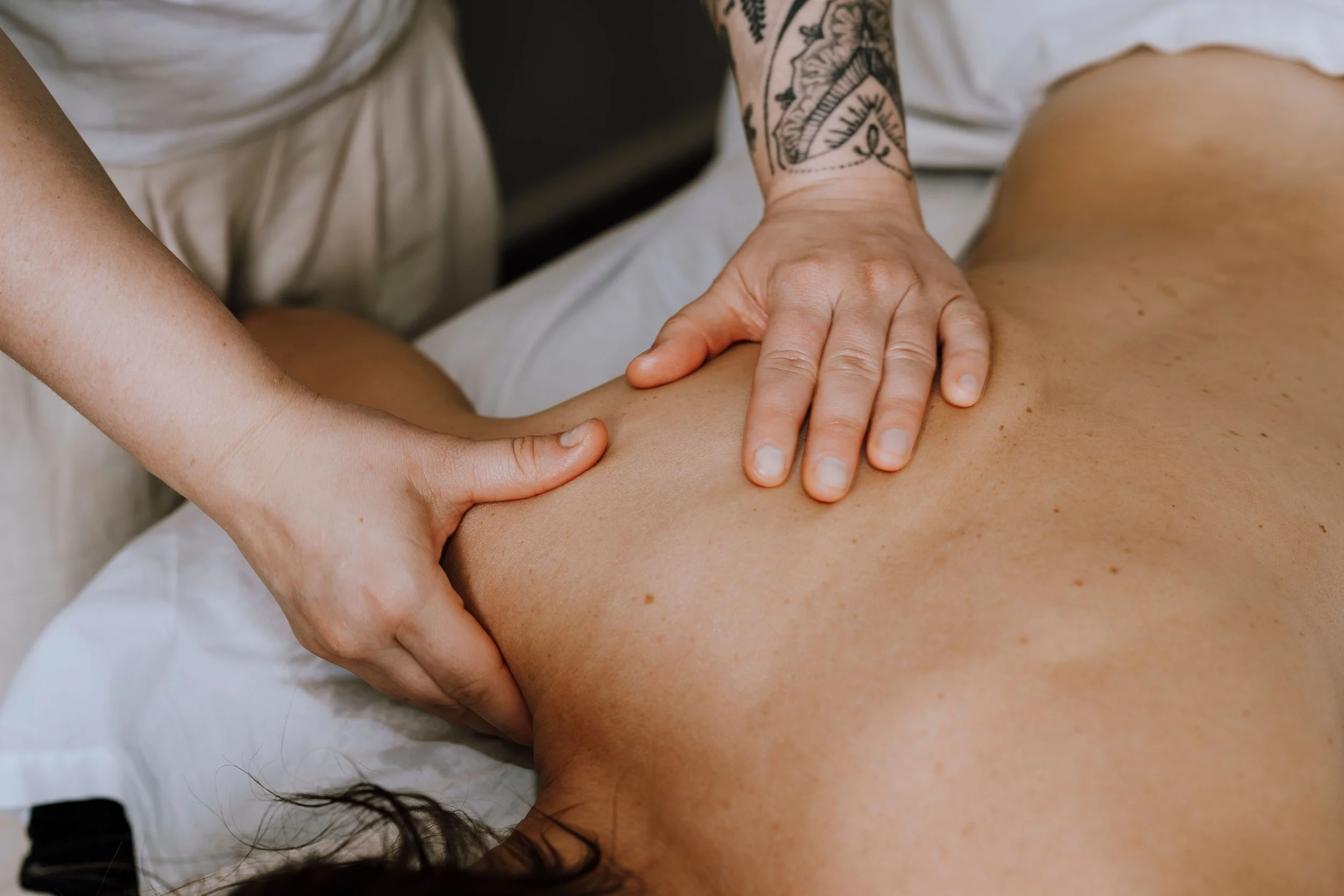 Person receiving a back massage from a massage therapist in a massage therapy setting.