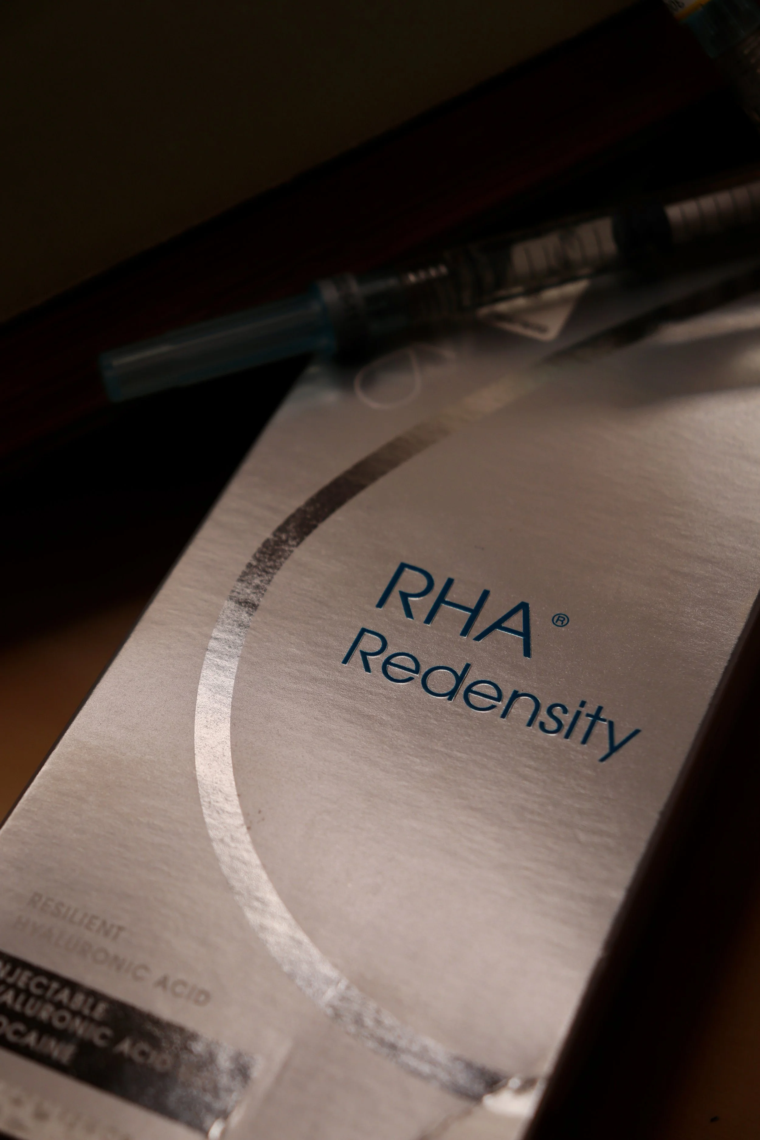 A box of RHA Redensity with a syringe on top of it.