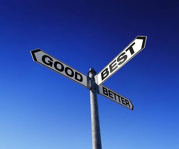 Street sign with four directional signs reading 'Good,' 'Best,' 'Better,' under a clear blue sky.