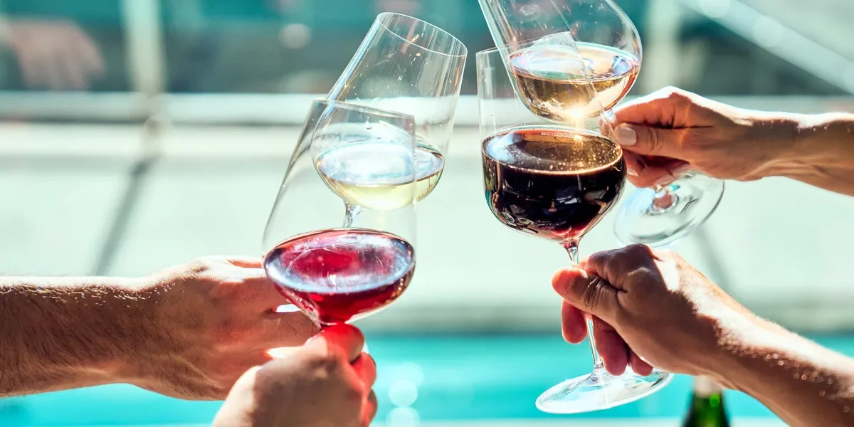 Four hands holding glasses of mixed wine to toast
