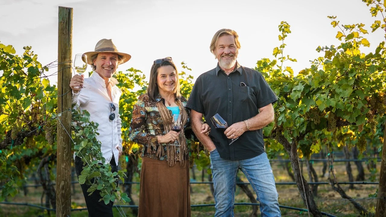 caleb, julie, and steve bosma in front of the vineyard