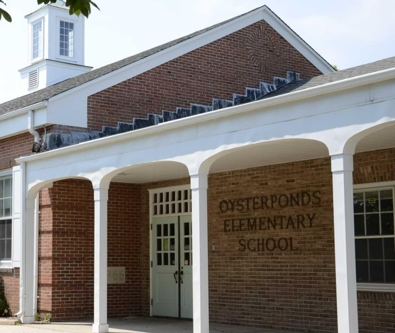 Exterior of Oyster Ponds Elementary School with a brick facade, white columns, and a covered entrance.