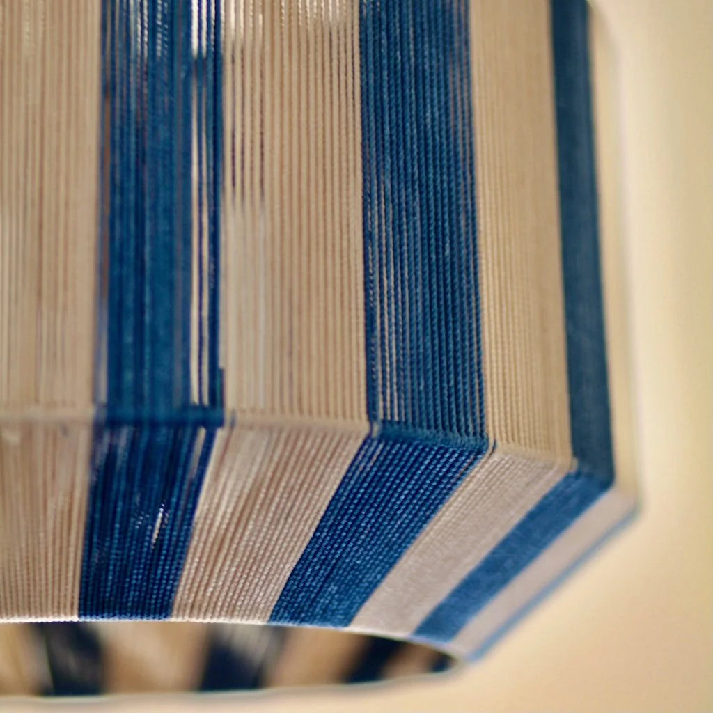 Close-up of the edge of a striped cardboard box with blue and beige vertical stripes.