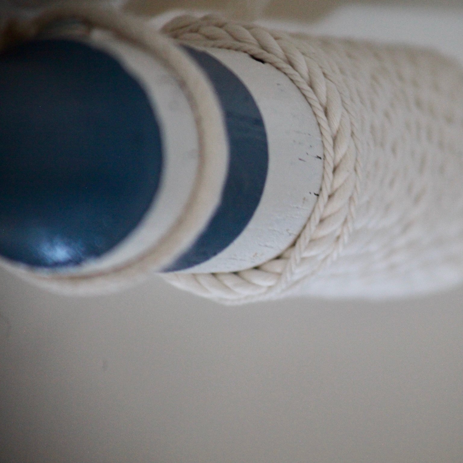 Close-up of a white and black striped telescopic tube with a loop of white rope around it.