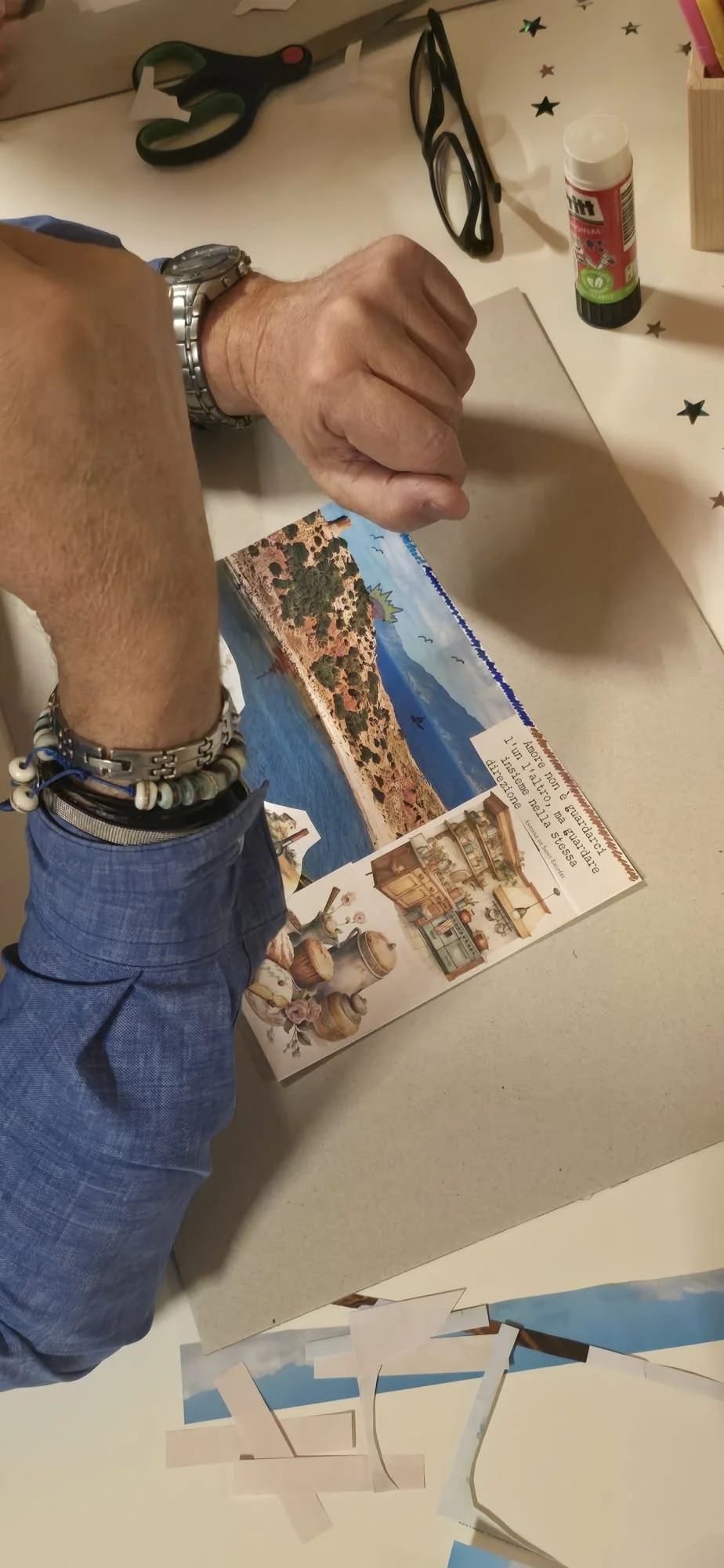 Mani che incollano parti di una grande cartolina decorativa con immagini di paesaggi, oggetti d'arredamento e testo.
