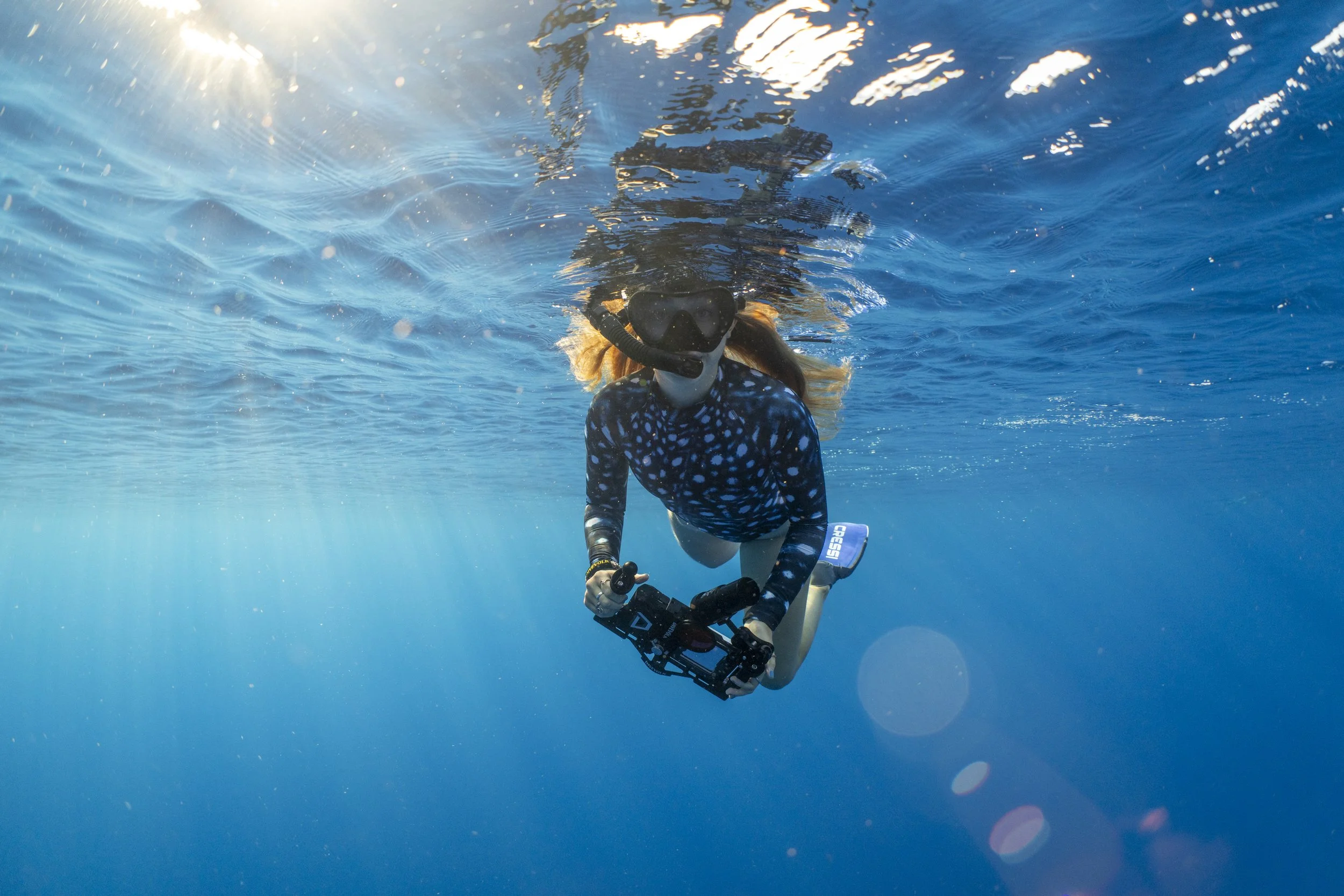 Environmental youth activist Olivia Mandle snorkeling in the ocean with an underwater camera