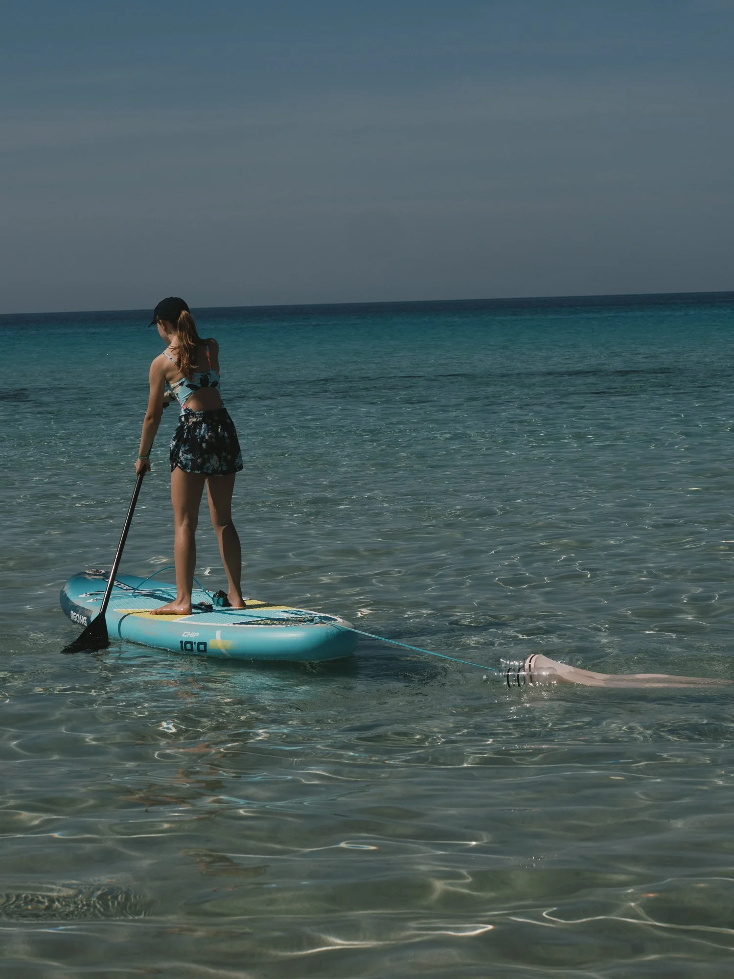 Environmental youth activist Olivia Mandle using her Jelly Cleaner microplastic filter on a stand up paddleboard