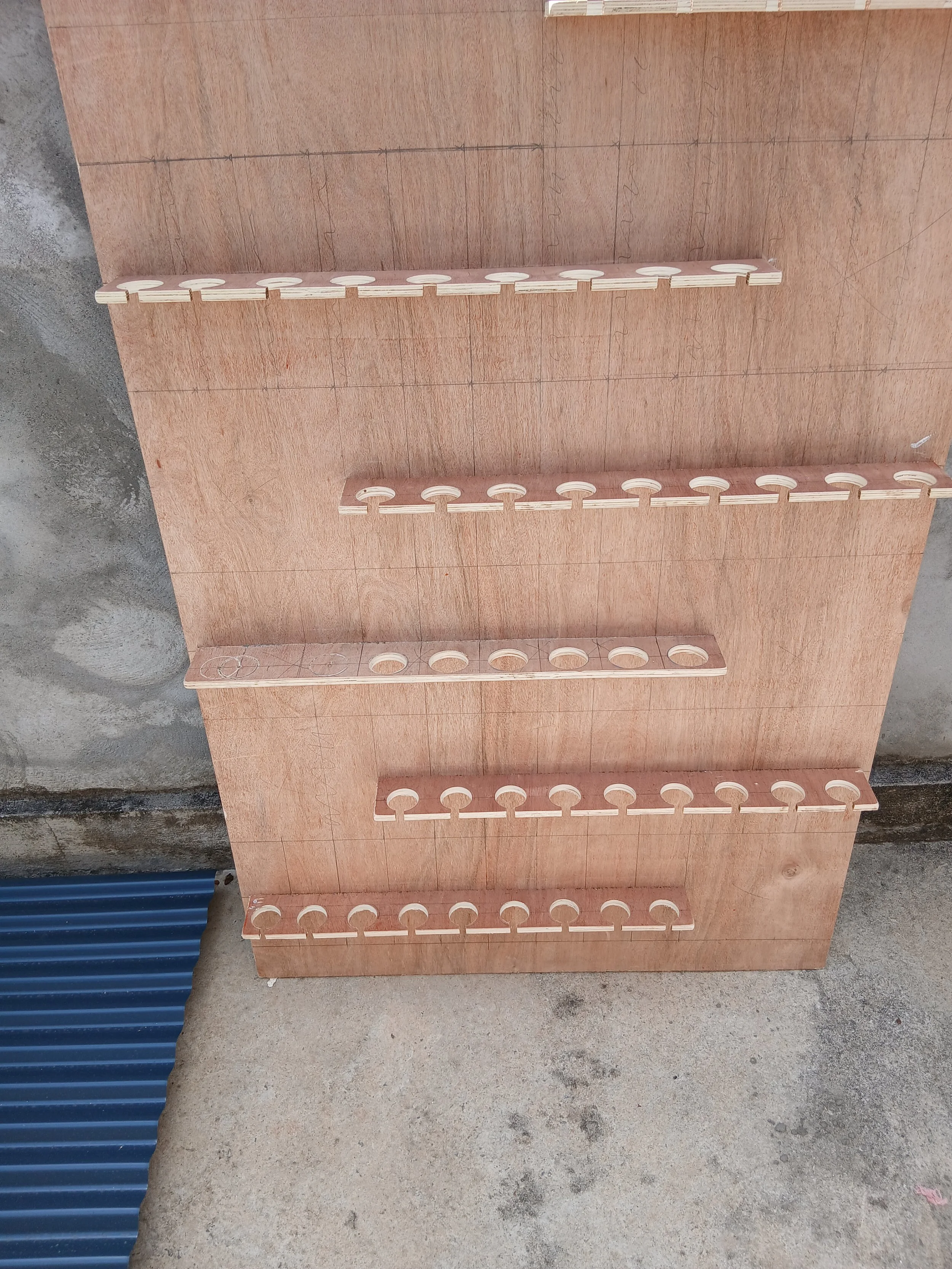 Une planche en bois avec plusieurs supports en bois fixés dessus,  pour tenir des verres de champagne.