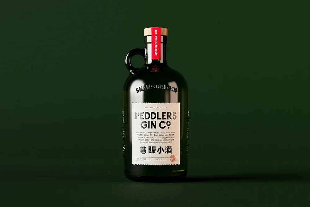 A dark green bottle of Peddlers Gin, Rare-Eastern, classic London Dry style Gin from Shanghai, award-winning and crafted for adventurous palates.