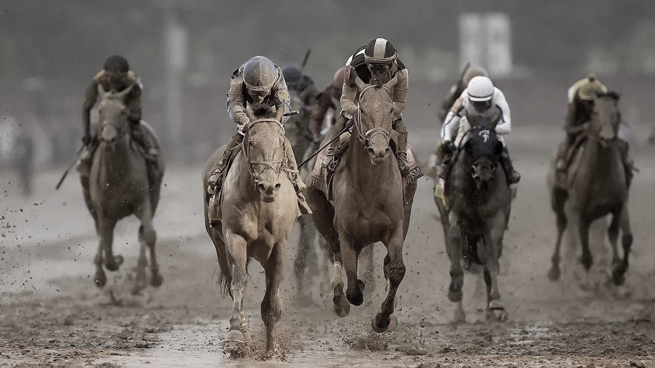 Horse racing with several jockeys riding horses on a dirt track, some jockeys wearing helmets and racing silks.
