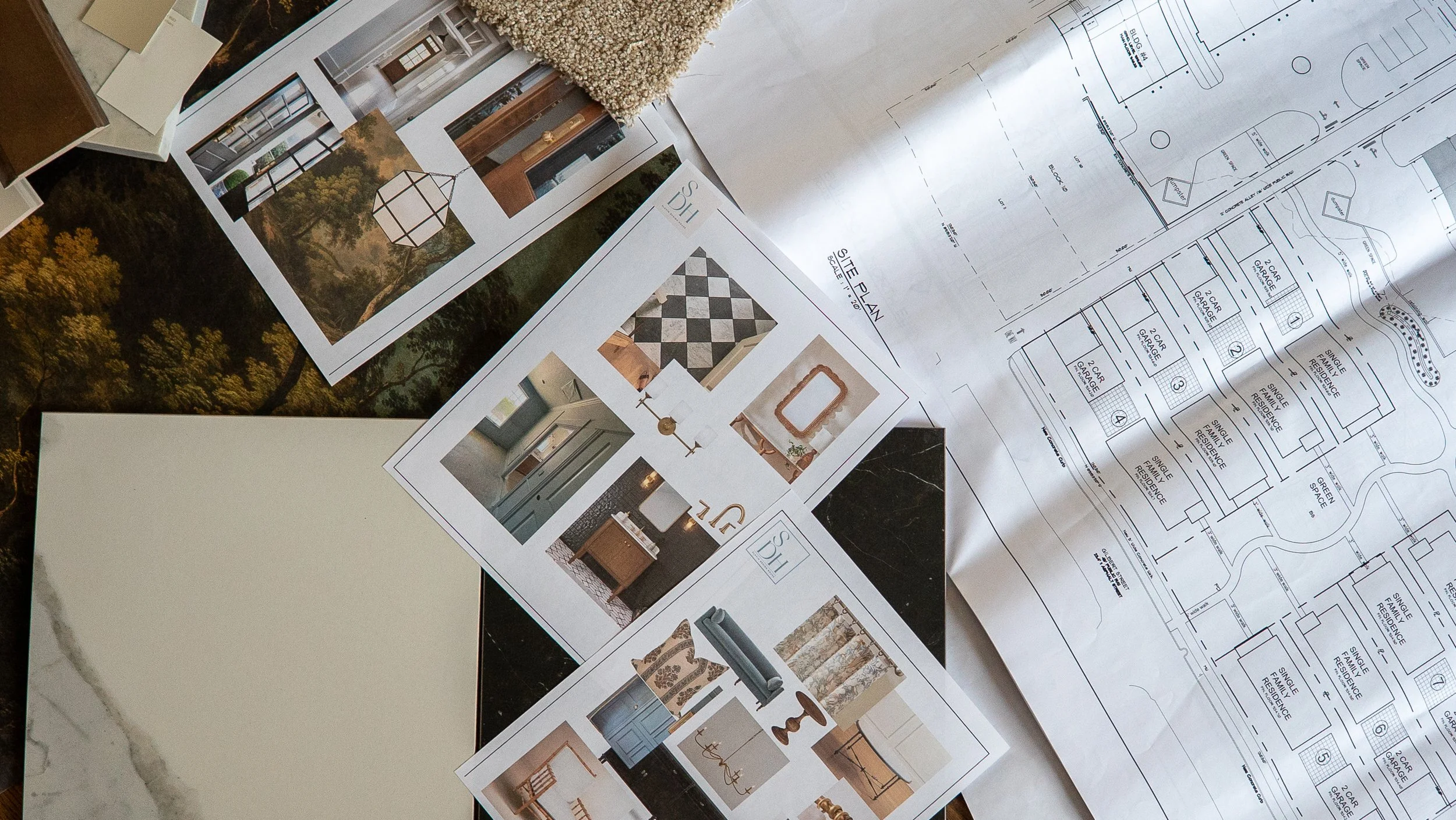 Architectural plans, interior design mood boards, and home layout blueprints spread out on a table.