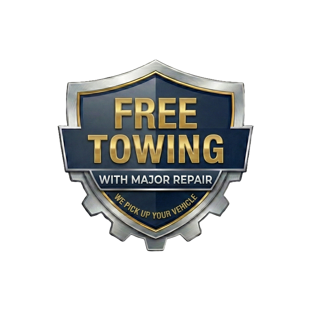 A badge with a metallic border, dark blue background, and gold lettering that reads 'Free Towing with Major Repair. We Pick Up Your Vehicle.'