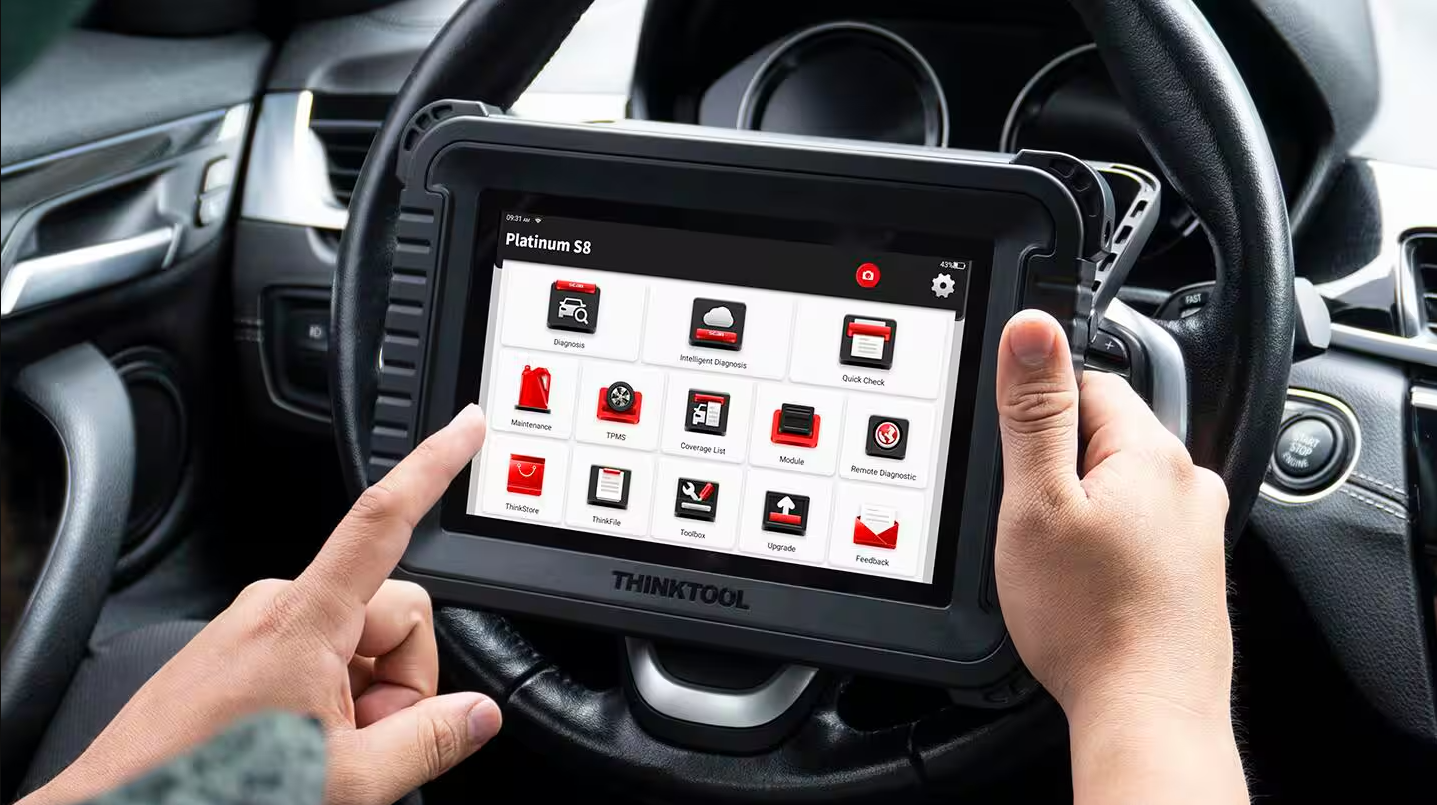 A person holding a ThinkTool diagnostic device inside a vehicle, accessing various diagnostic and maintenance options on its touchscreen.