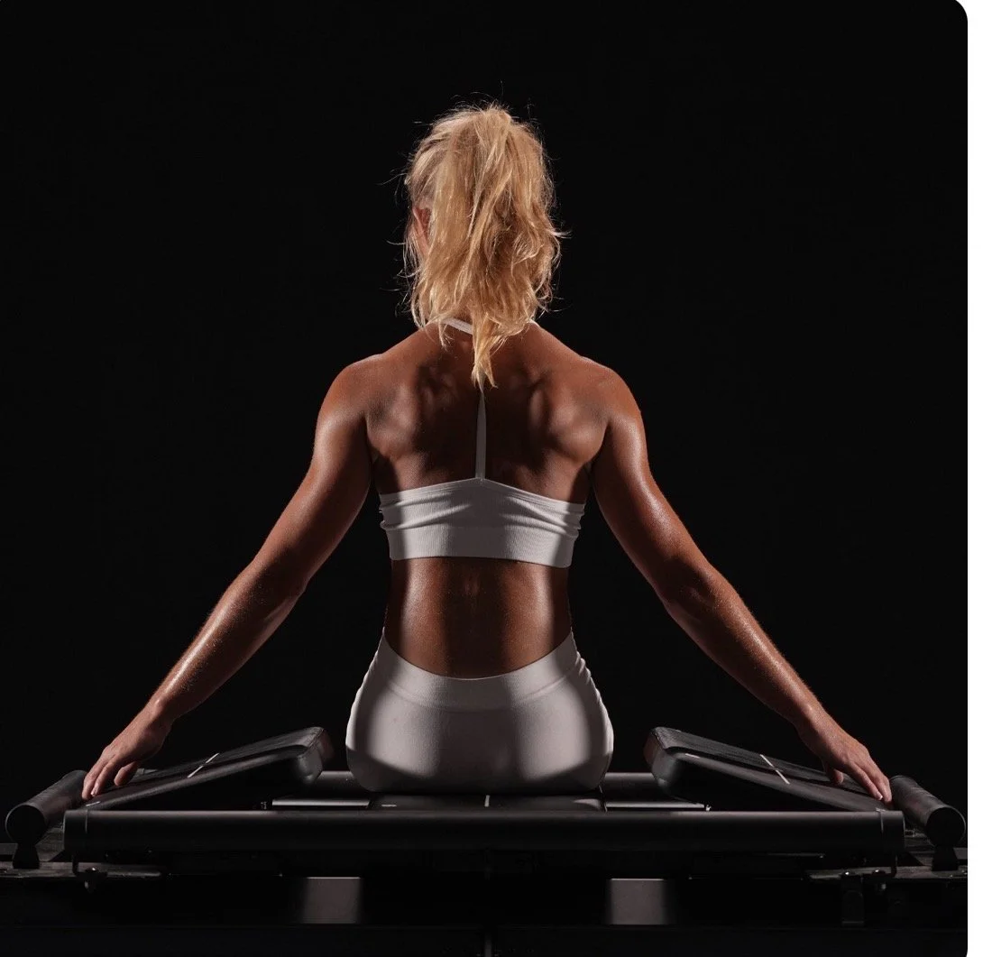 the back of a woman on a mega reformer