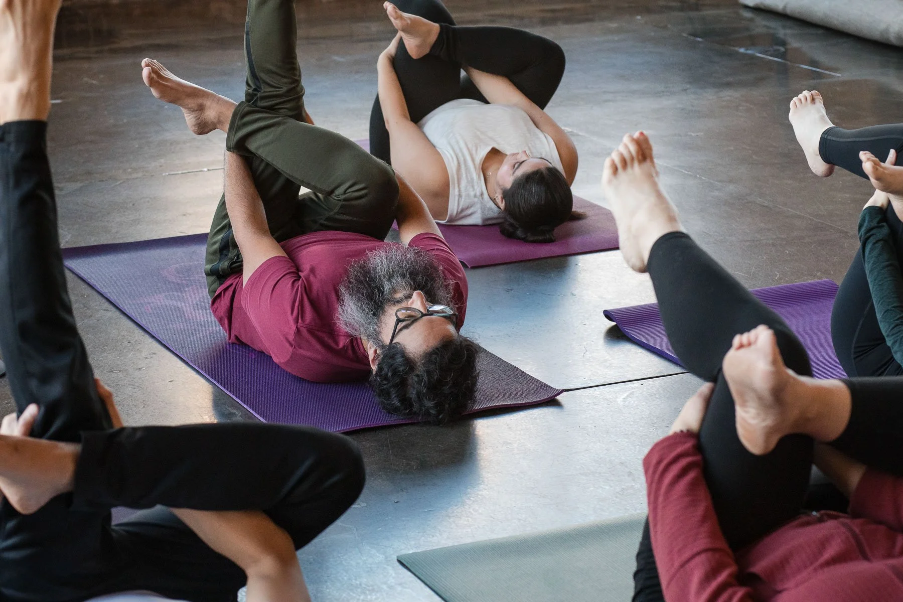 Group of people practicing yoga on mats in a studio.
