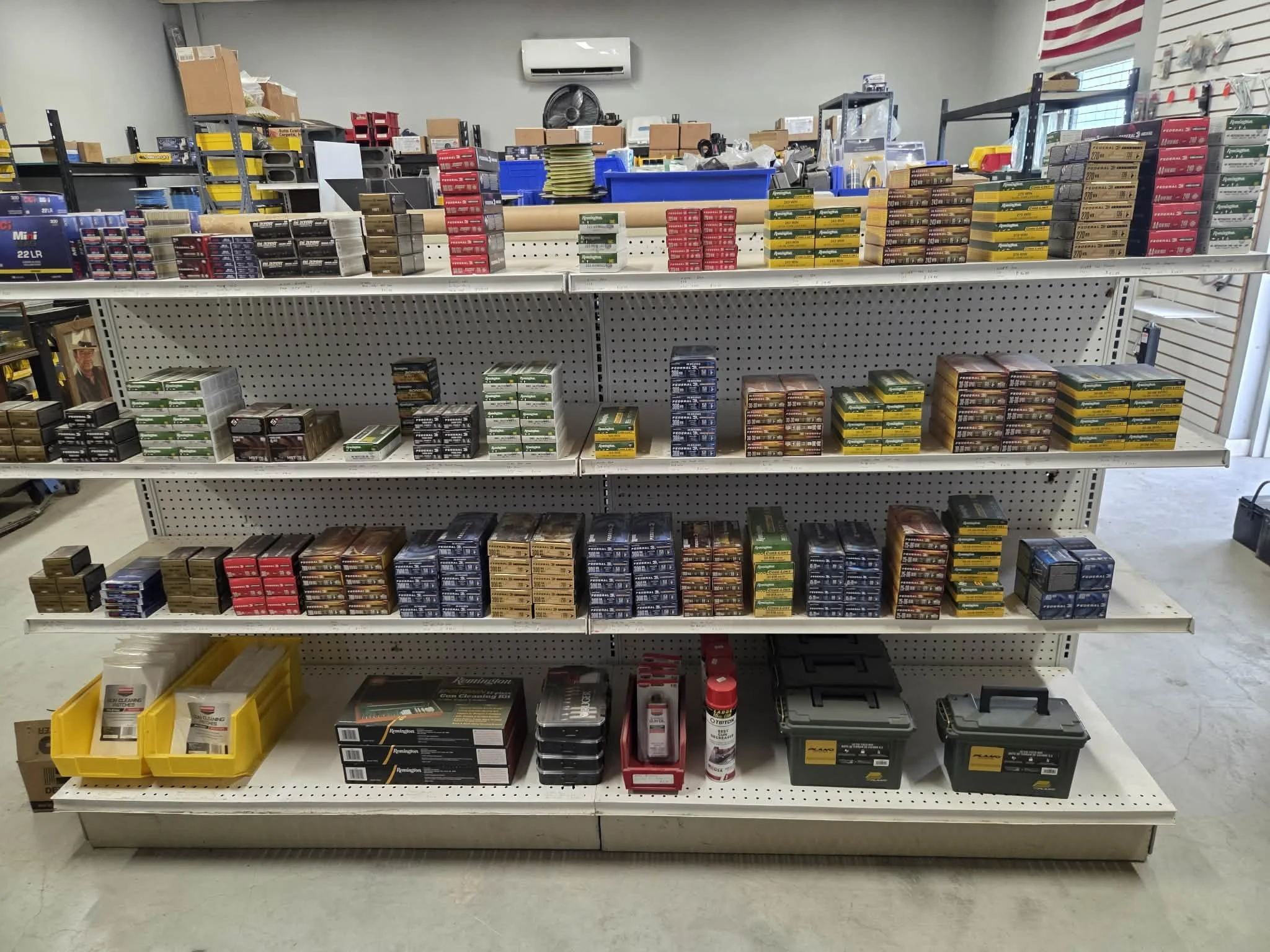 Store shelf stocked with various boxes of ammunition in a hardware or sporting goods store.