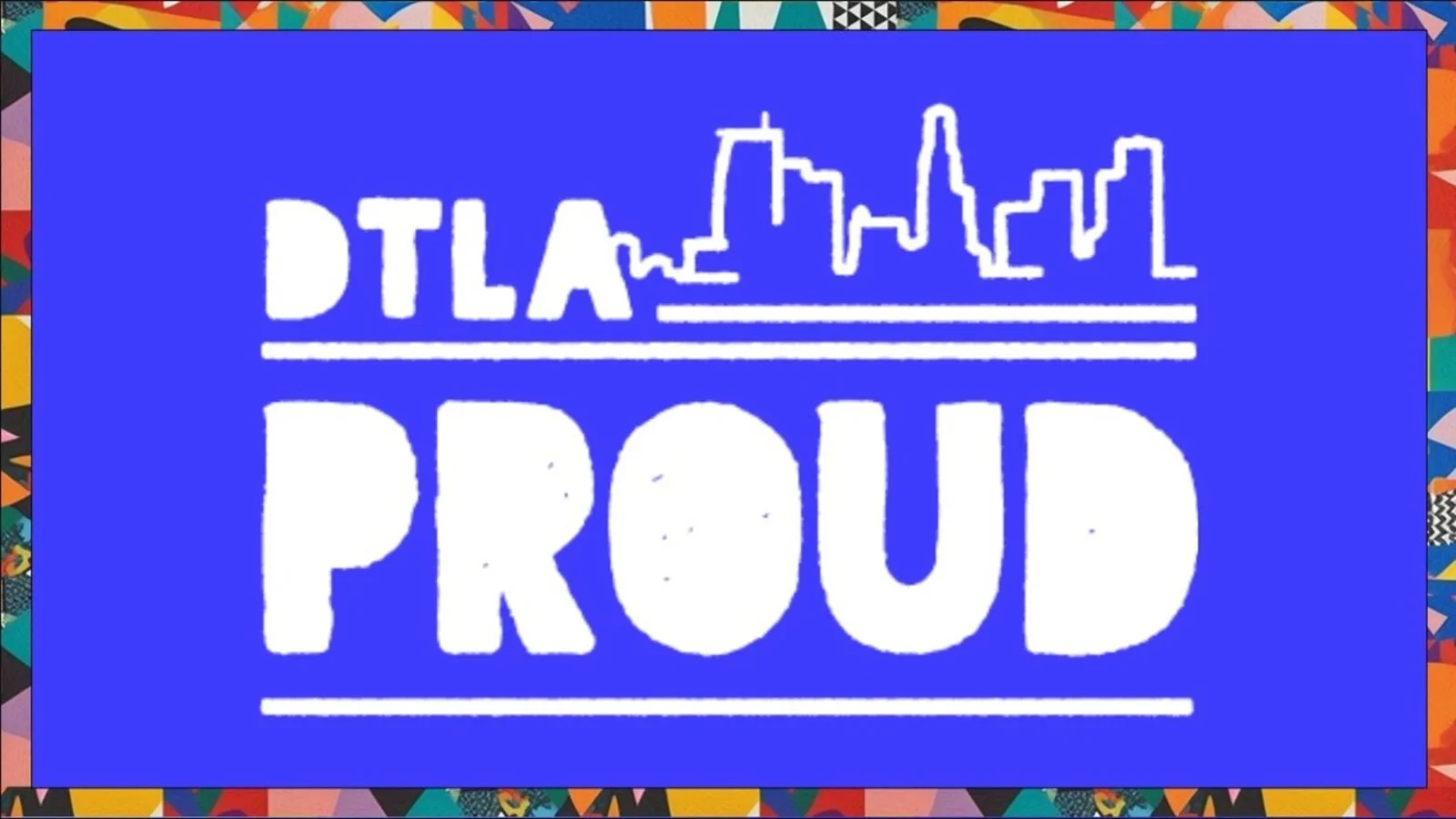 Logo for the Dallas Prouds, featuring an outline of the Dallas skyline above the words 'DTA Prouds' in white on a blue background, framed by a multicolored geometric border.