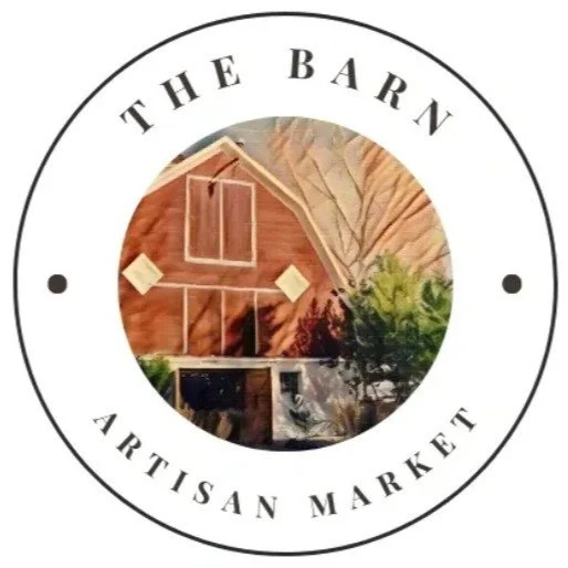 Logo for The Barn Artisan Market featuring a barn illustration inside a circular border with the text 'The Barn Artisan Market' around it.