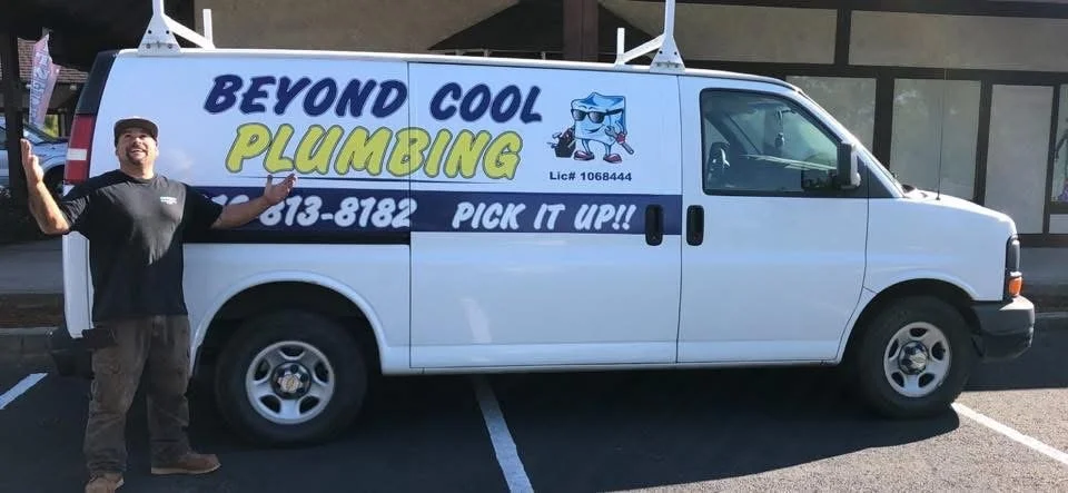 A man standing next to a white plumbing service van with the logo 'Beyond Cool Plumbing,' phone number, slogan 'Pick It Up!!', and cartoon character of a smiling pipette with sunglasses.