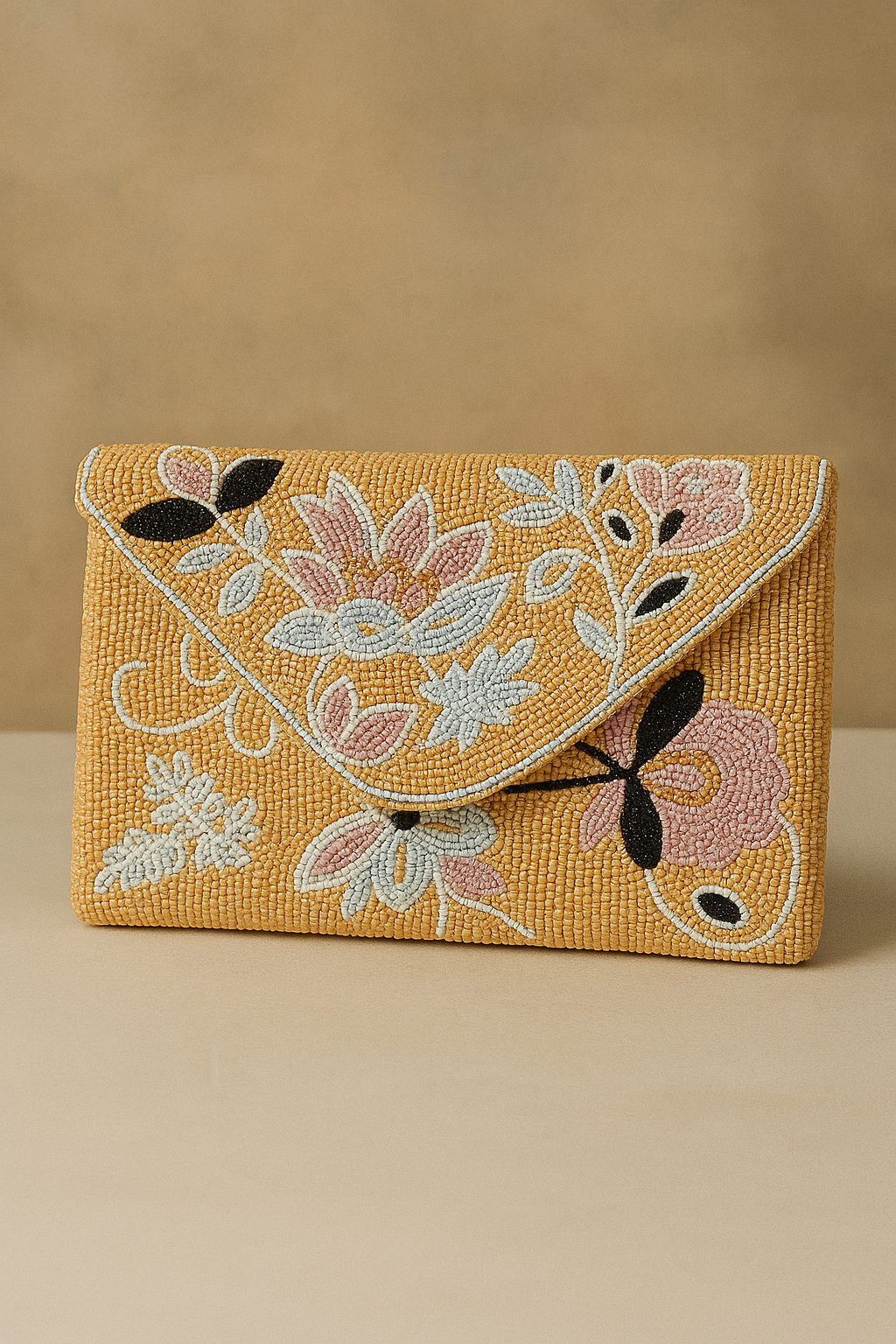 A yellow beaded clutch with pink, white, and black floral embroidery.